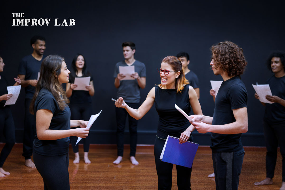 The Greenhouse Arts & Media Inc., The Improv Lab program logo image with an instructor giving guidance to two performers on a stage